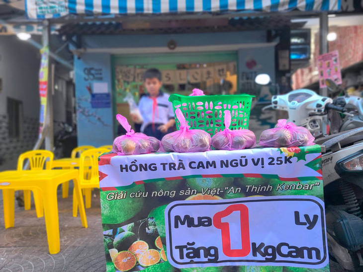 Quán Fuji Milk Tea nằm trên đường Bạch Vân (quận 5) treo biển mua 1 ly nước tặng 1kg cam nhằm giúp bà con tránh cảnh đổ bỏ nông sản - Ảnh: NHẬT XUÂN