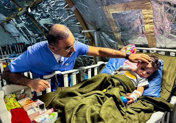 Bác sĩ Abdallah Al-Naqbi kiểm tra vết thương của bé Amir - Ảnh: CNN