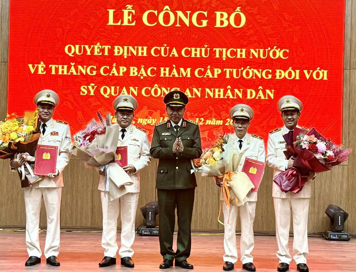 Thiếu tướng Mai Hoàng (bìa trái) nhận quyết định thăng cấp bậc hàm