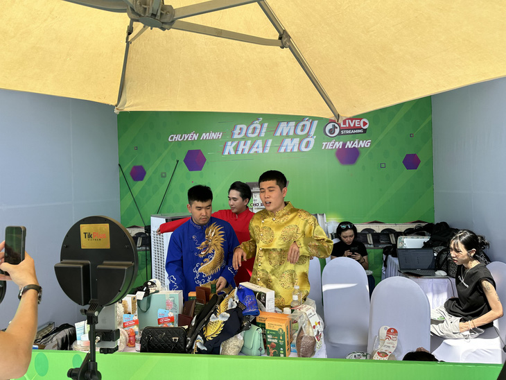 Hot TikToker Nguyễn Nhựt Linh (áo dài vàng) và TikToker Thanh Nhí (áo đai đỏ) phối hợp tiểu thương bán áo dài nam tại chợ Bến Thành - Ảnh: BTC