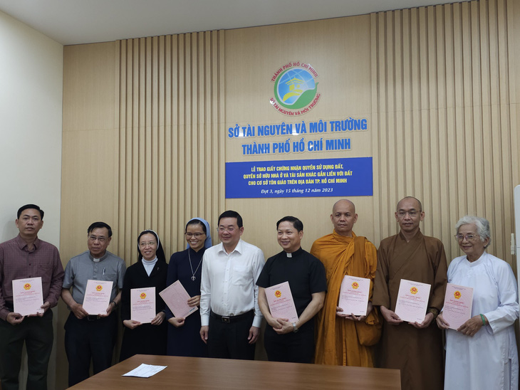 Giám đốc Sở Tài nguyên - Môi trường Nguyễn Toàn Thắng trao sổ hồng cho đại diện các cơ sở tôn giáo chiều 15-12 - Ảnh: ÁI NHÂN
