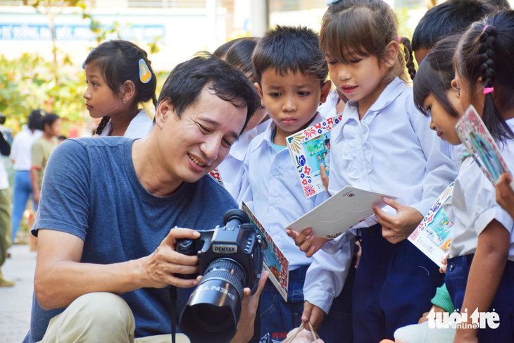 Các em nhỏ thích thú xem lại các hình ảnh do nhiếp ảnh gia chụp - Ảnh: TRẦN HOÀI