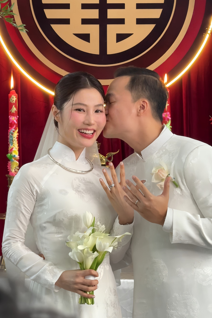Mẹ Vinh Nguyễn tặng và tự tay đeo trang sức cho Diễm My. Vợ chồng diễn viên hôn má nhau trong tiếng hò reo, chúc phúc của người thân.