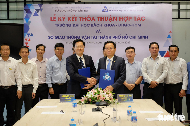Ông Trần Quang Lâm, giám đốc Sở Giao thông vận tải TP.HCM (hàng đầu, bên trái) và PGS.TS Mai Thanh Phong, hiệu trưởng Trường ĐH Bách khoa TP.HCM (bên phải) ký kết hợp tác - Ảnh: PHƯƠNG NHI