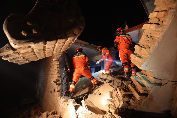 Lực lượng cứu hộ tìm kiếm người sống sót trong các căn nhà đổ nát ở Cam Túc, Trung Quốc, ngày 19-12 - Ảnh: AFP