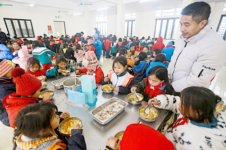 Ông Ngô Xuân Dũng, hiệu phó Trường phổ thông dân tộc bán trú Tiểu học Hoàng Thu Phố 1, trực tiếp theo dõi, hỗ trợ học sinh ăn trưa ngày 19-12 - Ảnh: CHÍ TUỆ