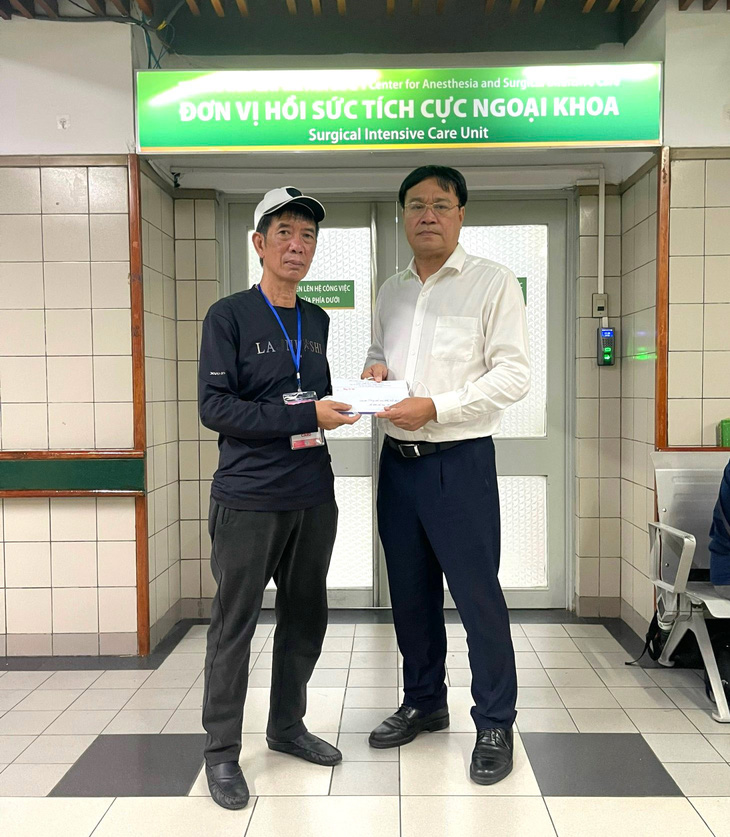 Ông Đặng Hà Việt (phải) - cục trưởng Cục TDTT đến thăm, động viên Nguyễn Minh Triết và gia đình em tại bệnh viện - Ảnh: TDDCVN