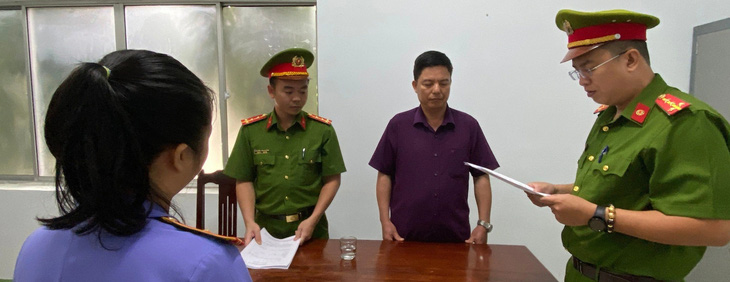Cơ quan công an tống đạt quyết định khởi tố bị can Vũ Văn Quân, nguyên trưởng Phòng TN&MT huyện Thuận Nam - Ảnh: Công an cung cấp