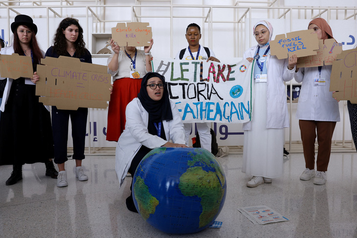 Thành viên của Liên đoàn Sinh viên Y khoa Quốc tế giơ biểu ngữ yêu cầu chấm dứt nhiên liệu hóa thạch COP28. Ảnh: REUTERS