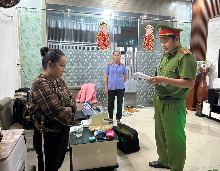 Cơ quan điều tra tống đạt quyết định khởi tố Nguyễn Thị Khánh Vân để điều tra hành vi mua bán trái phép hóa đơn - Ảnh: H.B.
