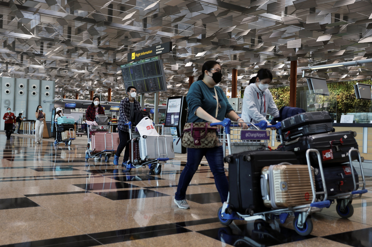 Hành khách di chuyển bên trong sân bay quốc tế Changi, Singapore vào ngày 30-3-2020 - Ảnh: REUTERS