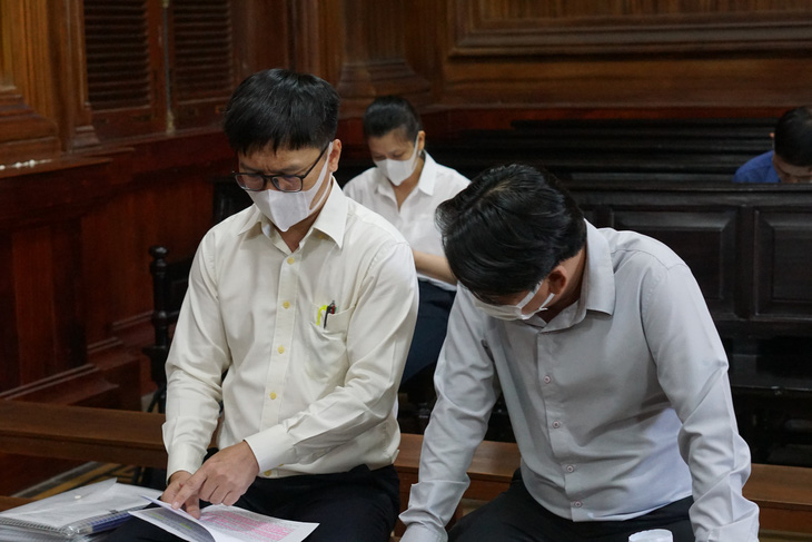 Ông Nguyễn Văn Tùng (áo trắng, bìa trái) và ông Nguyễn Quốc Tuấn tại tòa - Ảnh: TUYẾT MAI