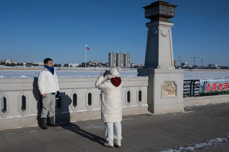 Người dân Trung Quốc chụp ảnh kỷ niệm gần sông Amur (Nga) ở biên giới Nga - Trung - Ảnh: NEW YORK TIMES