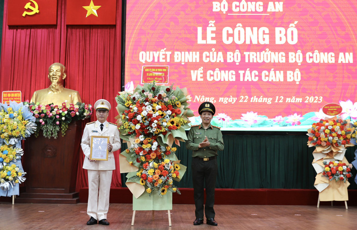 Trung tướng Lê Văn Tuyến - thứ trưởng Bộ Công an (bên phải) - trao quyết định, tặng hoa chúc mừng đại tá Nguyễn Thanh Liêm - giám đốc Công an tỉnh Đắk Nông - Ảnh: MINH QUỲNH