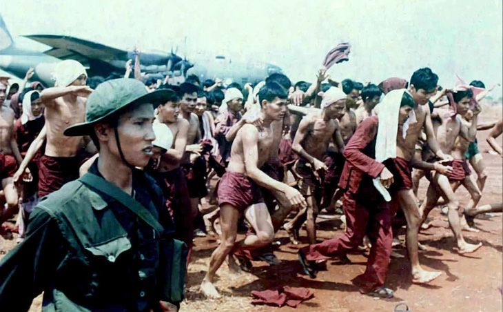 Các tù binh cởi ngay áo tù khi xuống phi trường Lộc Ninh - Ảnh: Flickr