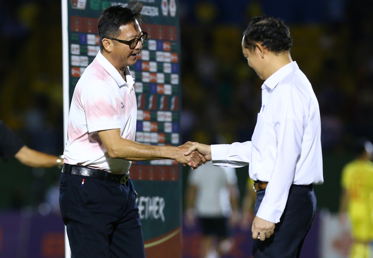 HLV Lê Huỳnh Đức (trái) chia vui cùng lãnh đạo đội bóng - Ảnh: Q.T.