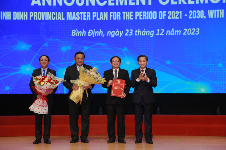 Phó thủ tướng Lê Minh Khái (bìa phải) trao quyết định của Thủ tướng Chính phủ phê duyệt quy hoạch tỉnh Bình Định thời kỳ 2021-2030, tầm nhìn 2050 cho lãnh đạo tỉnh Bình Định - Ảnh: NGUYỄN DŨNG