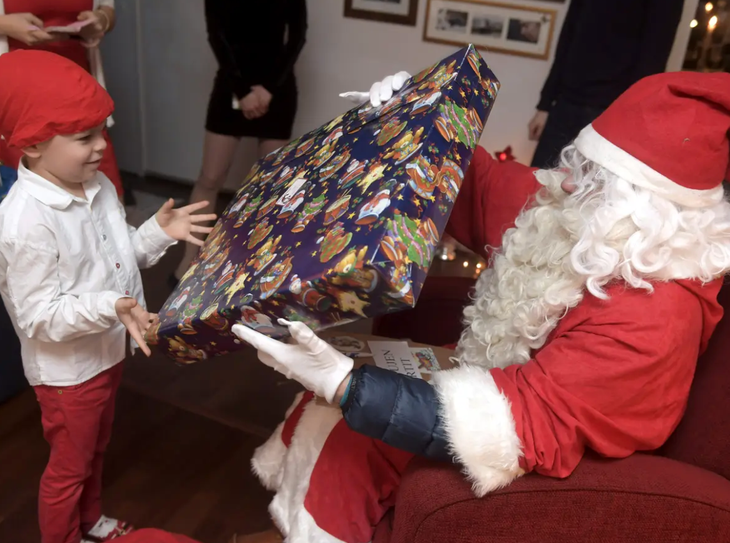 Ông già Noel trao quà cho một em nhỏ Phần Lan - Ảnh: REUTERS