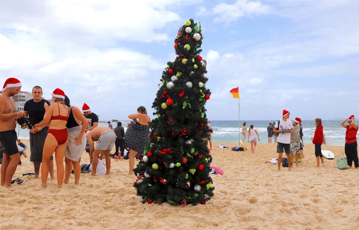 Người dân đón Giáng sinh trên bãi biển Bondi gần thành phố Sydney - Ảnh: REUTERS