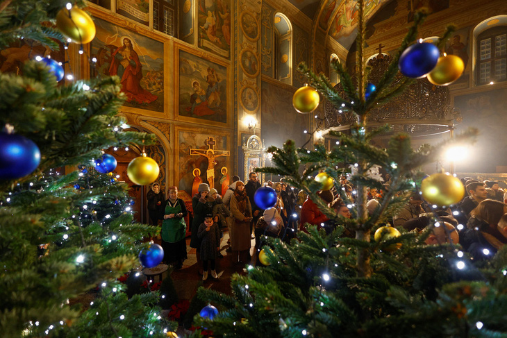 Các tín đồ tham dự lễ Giáng sinh tại một nhà thờ ở Kiev, Ukraine ngày 24-12 - Ảnh: REUTERS