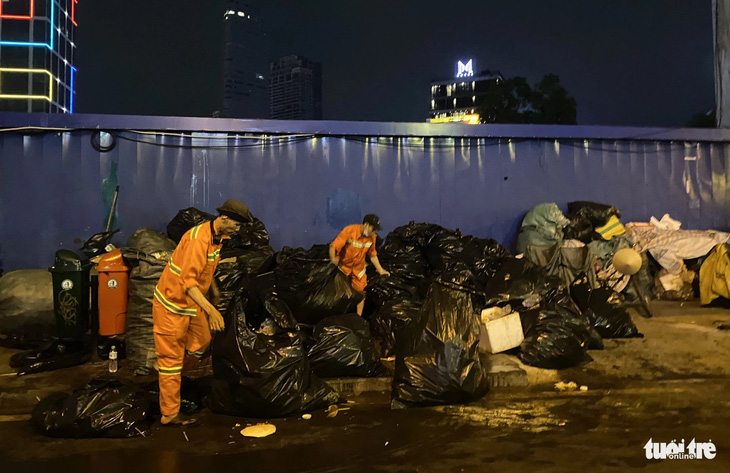 Nhiều công nhân vệ sinh cũng tỏ ra choáng ngợp khi phải phân loại số lượng rác lớn - Ảnh: TIẾN QUỐC