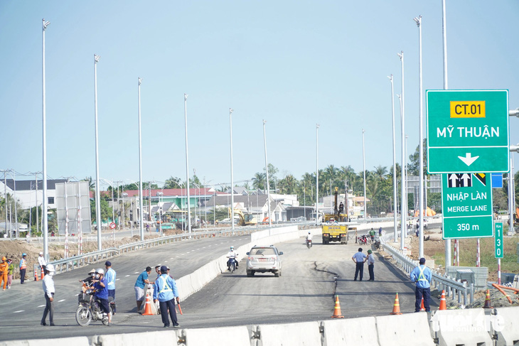 Nhân viên bảo vệ giăng cọc, tài xế than khó tìm lối vào cao tốc Mỹ Thuận - Cần Thơ chính thức thông xe - Ảnh: CHÍ HẠNH