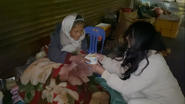 Niềm vui nho nhỏ của một phụ nữ vô gia cư khi được các bạn trẻ tặng hộp xôi nóng, bịch sữa giữa trời rét căm căm trong đêm Giáng sinh tại Hà Nội - Ảnh: HÀ QUÂN