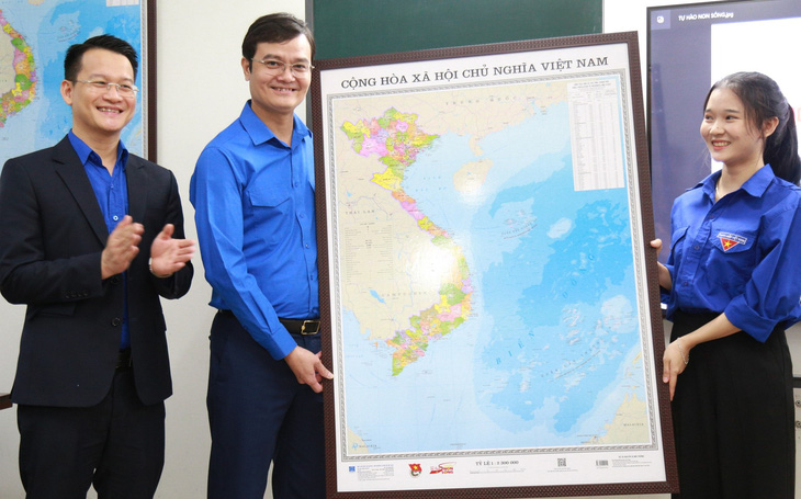 Anh Bùi Quang Huy (trái) trao bản đồ cho học sinh Trường THPT Phan Châu Trinh (Đà Nẵng) - Ảnh: Đ.NHẠN