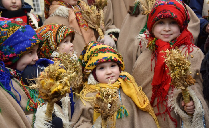 Trẻ em Ukraine cầm bó lúa mì didukh trong buổi diễu hành Giáng sinh tại vùng Lviv - Ảnh: GETTY IMAGES
