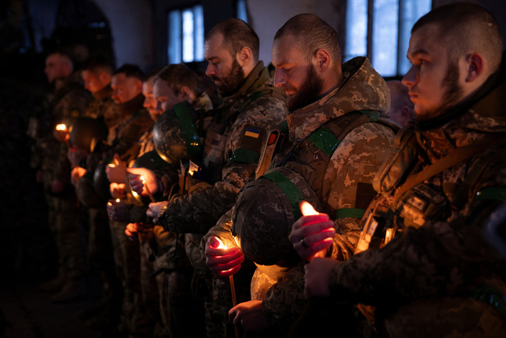 Các binh sĩ Ukraine thuộc lữ đoàn cơ giới số 14 cầm nến trong buổi lễ đêm Giáng sinh gần tiền tuyến bên ngoài Kupiansk, ngày 24-12 - Ảnh: REUTERS