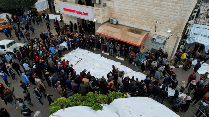 Những người đưa tang tụ tập bên cạnh thi thể của những người Palestine thiệt mạng trong các cuộc tấn công của Israel tại một bệnh viện ở trung tâm Dải Gaza, ngày 25-12 - Ảnh: REUTERS