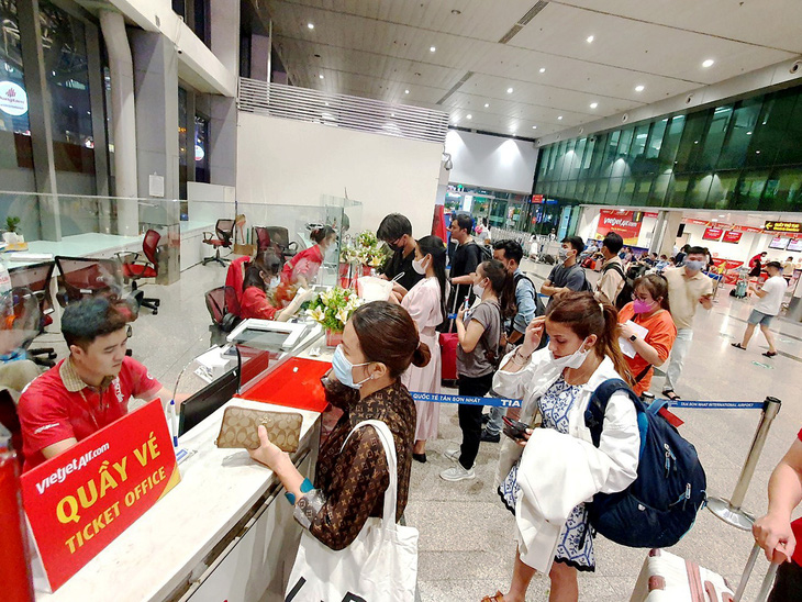 Hành khách mua vé máy bay Vietjet ở quầy vé sân bay Tân Sơn Nhất - Ảnh: CÔNG TRUNG