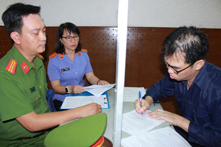 Bị can Đinh Trường Chinh (phải) làm việc với cơ quan chức năng - Ảnh: Công an cung cấp
