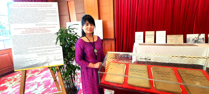 Bà Trương Thị Thanh Hương bên cạnh bộ hồ sơ cầu Trường Tiền mà bà đã mua để mang về tặng cho Huế - Ảnh: M.TỰ