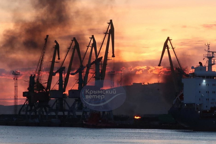 Ukraine công bố hình ảnh khói bốc lên từ tàu chiến Nga bị trúng tên lửa ở cảng Feodosia trên bán đảo Crimea ngày 26-12 - Ảnh: AFP