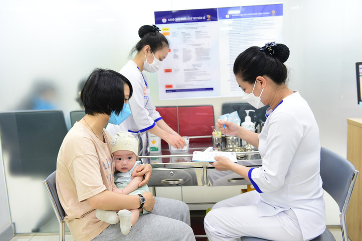 Trẻ chuẩn bị được tiêm ngừa tại một trung tâm tiêm chủng vắc xin - Ảnh: DUYÊN PHAN