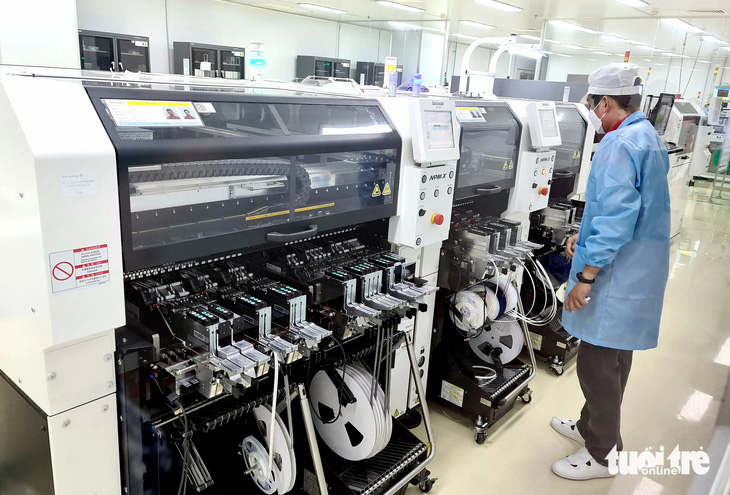 Công nhân sản xuất các thiết bị điện tại nhà máy của Công ty CP Bóng đèn Điện Quang ở TP.HCM - Ảnh: NGỌC HIỂN
