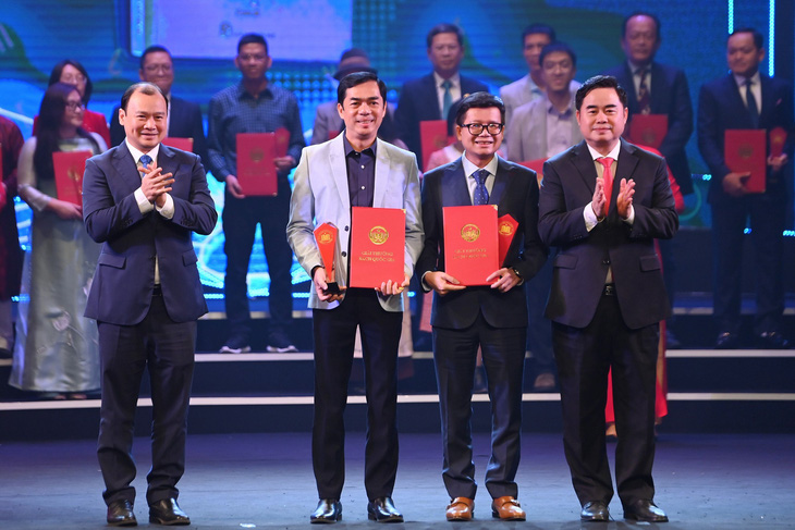 Phó tổng biên tập báo Tuổi Trẻ Nguyễn Khắc Cường (hàng đầu, thứ hai từ trái sang) nhận giải B Giải thưởng Sách quốc gia - Ảnh: BTC