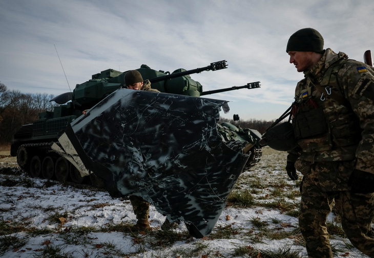 Quân nhân Ukraine từ đơn vị phòng không khiêng một bộ phận của máy bay không người lái cảm tử của Nga bị bắn rơi vài ngày trước ở gần Kiev, Ukraine, ngày 30-11 - Ảnh: REUTERS