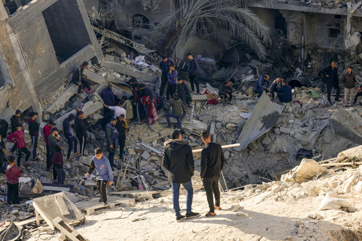 Người dân bên đống đổ nát sau trận pháo kích đêm 3-12 của Israel nhằm vào thành phố Rafah, miền nam Dải Gaza - Ảnh: AFP