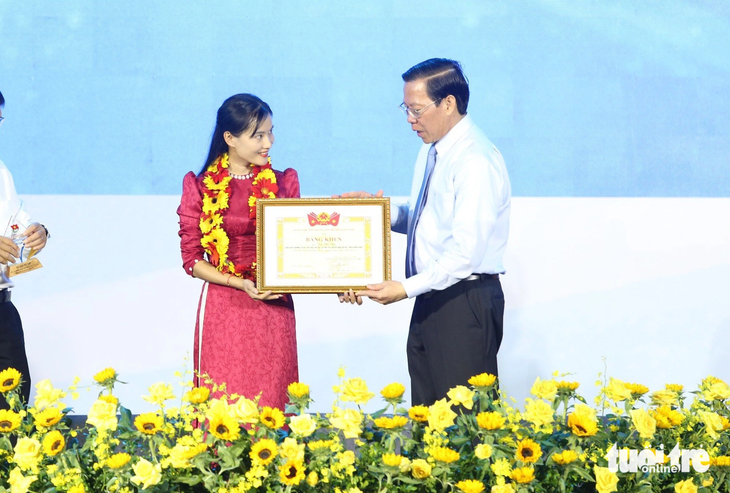 Ông Phan Văn Mãi, chủ tịch UBND TP.HCM, trao giải thưởng Tình nguyện quốc gia năm 2023 cho cô giáo Trà Thị Thu - Ảnh: CÔNG TRIỆU