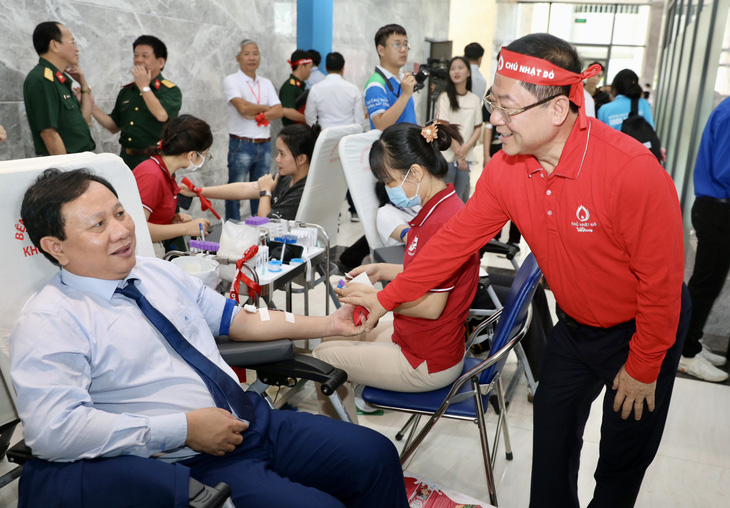 Tổng biên tập báo Tiền Phong Lê Xuân Sơn (bên phải) - trưởng ban tổ chức chương trình - thăm hỏi người đến hiến máu tại chương trình - Ảnh: PHẠM NGUYỄN