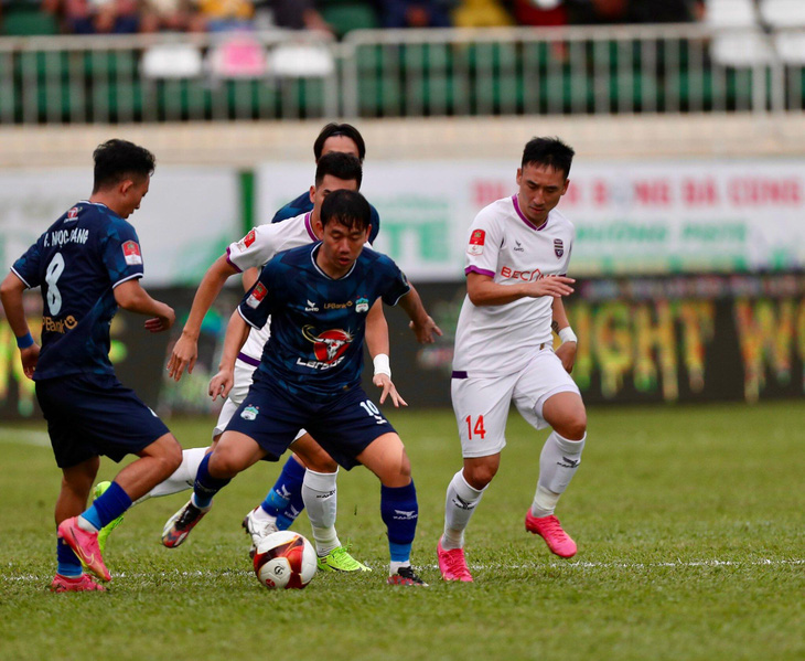 Pha tranh bóng giữa cầu thủ Hoàng Anh Gia Lai với Becamex Bình Dương (áo trắng) - Ảnh: MINH ANH