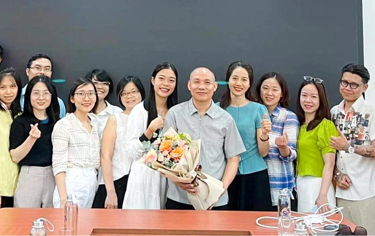 PGS.TS Vũ Tiến Hồng (cầm hoa) trong một buổi thảo luận với học viên sau đại học của Đại học Quốc gia Hà Nội - Ảnh: NVCC