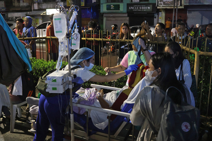 Nhân viên y tế sơ cứu người dân bị thương sau trận động đất tối 2-12 - Ảnh: AFP
