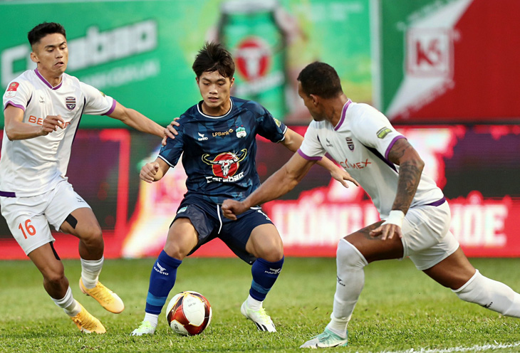 Tiền đạo Quốc Việt (giữa) trong trận đấu với B.Bình Dương - Ảnh: MINH ANH