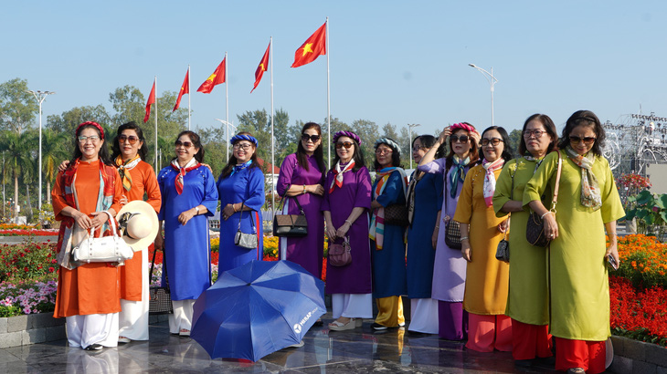 Nhóm du khách đến từ tỉnh Hậu Giang chụp ảnh tại quảng trường TP Sa Đéc sáng 29-12 - Ảnh: TRƯƠNG KIÊN