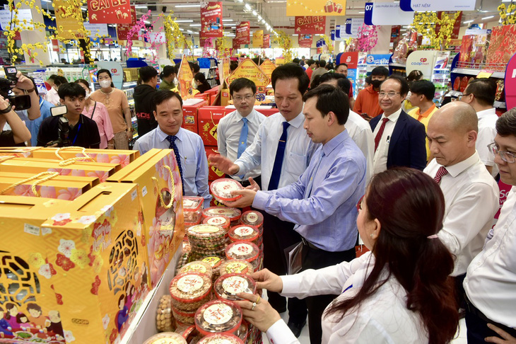 Chủ tịch HĐQT Saigon Co.op Vũ Anh Khoa (áo xanh) giới thiệu các sản phẩm tại siêu thị với lãnh đạo địa phương và TP.HCM - Ảnh: T.T.D.