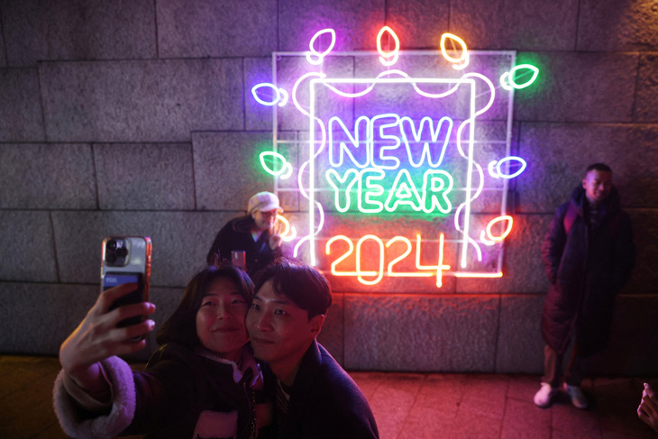 Một cặp đôi chụp ảnh tự sướng trong đêm giao thừa ở Seoul, Hàn Quốc, ngày 31-12 - Ảnh: REUTERS
