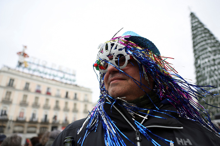 Một người đàn ông đeo kính mừng năm mới 2024 trong buổi diễn tập cho lễ đón giao thừa tại quảng trường Puerta del Sol nổi tiếng ở Madrid, Tây Ban Nha, ngày 31-12 - Ảnh: REUTERS